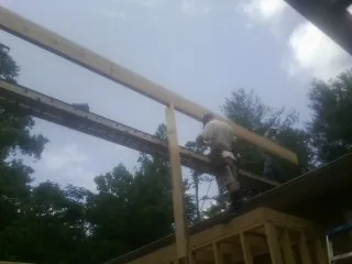 Carpenter setting a ridge beam over a new addition frame — Ice Dam Removal by Roofing Brothers in Blackwood